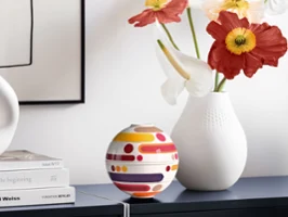 Composizione decorativa con La Petite Boule Miami e un vaso bianco su un credenza chiara.
