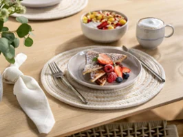 Service de table petit-déjeuner et dessert inspiré du style bohème avec vaisselle Villeroy & Boch Perlemor Sand – tasse, bol à muesli et assiette – sur une table en bois rustique au charme naturel et décontracté.