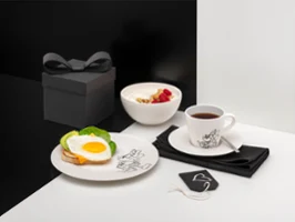 Manufacture Disney breakfast service with a fried egg on toast, a bowl of yoghurt with fruit, a cup of tea and a black gift box.