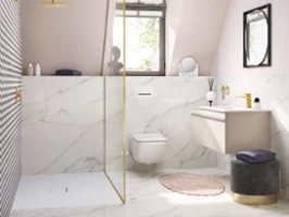 Lavabo Venticello blanco en cuarto de baño rosa Un lavabo Venticello blanco en un baño rosa con techo inclinado y grifería dorada