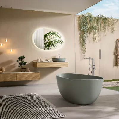 Un bagno moderno con vasca verde della collezione Antao e mobili in legno coordinati.