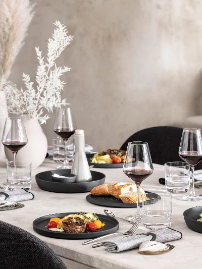 A dining table with a black La Boule being used with food as well as an assembled La Boule as decoration.