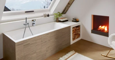 Une baignoire Subway 3.0 dans une salle de bains mansardée avec une cheminée.