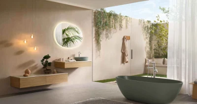 Minimalist Antao bathroom with modern taps, a floating wooden washstand, a round mirror with backlighting, hanging lamps, a freestanding bath, a large window, plants and a view of the garden.