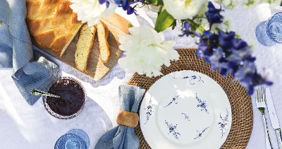 Op een gedekte tafel staan een Vieux Luxembourg bord van Villeroy & Boch, een stoffen servet, een mes, een vork en een pot donkere jam.