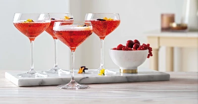 Four champagne glasses from the Purismo collection with berries on a tray.