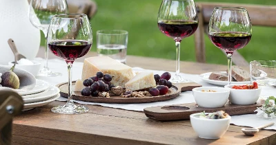 A table with Purismo red wine glasses, dip bowls and antipasti platter from Artesano on top.