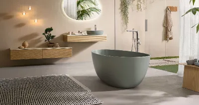 Un bagno moderno con vasca verde della collezione Antao e mobili in legno coordinati.