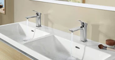 Une robinetterie Subway 3.0 montée sur un lavabo double et un meuble sous plan.