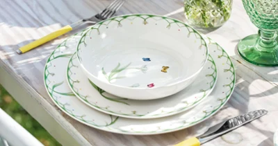 An outdoor set table with a Colourful Spring table setting and green Boston glasses under natural light.