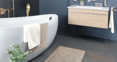 Tessuti per il bagno Villeroy & Boch in un bagno con vasca bianca e lavabo in legno.