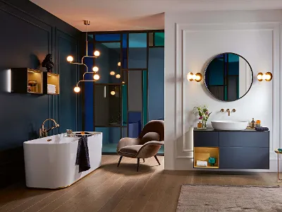 Finion Badewanne in einem klassischen Badezimmer mit blauen Wänden und Holzböden.