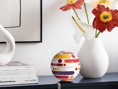 Decorative arrangement with La petite Boule Miami and a white vase on a light sideboard.