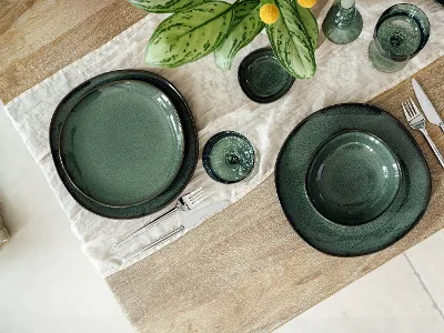Aerial view of Lave Vert dinnerware on a boho table setting paired with the Like Sage glassware.