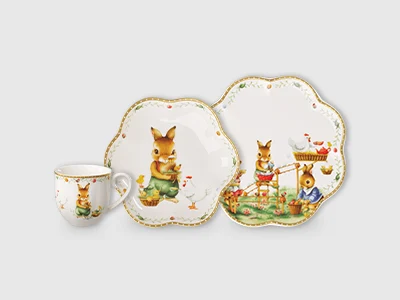 Three porcelain plates with wavy rim and illustrations and little bunnies in clothes.