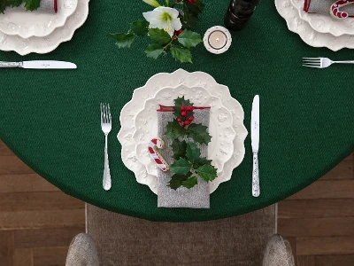 A Christmas table setting with a green tablecloth, white plates decorated with holly from the Villeroy & Boch Toy's Delight Royal Classic collection, a candy cane, a sprig of holly on the napkin and silver cutlery.