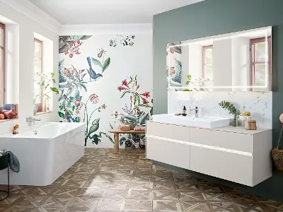 Un lavabo, des meubles et une baignoire Collaro dans une salle de bains avec un papier peint à fleurs.