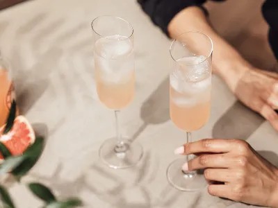 Person holding NewMoon champagne glass with sparkling drink in it