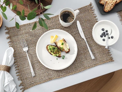 Una tavola apparecchiata con una tazza di caffè e un piatto bianco Artesano di Villeroy & Boch con del cibo.