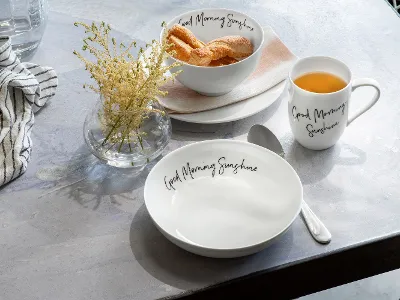 Et bord med en Statement-kaffekopp og en Statement-tallerken med croissanter fra Villeroy & Boch.