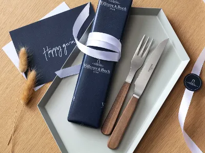 Texas Steakbesteck von Villeroy & Boch mit Holzgriff als Geschenk mit blauer Geschenkverpackung und weißer Schleife.