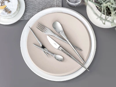 NewMoon table setting from Villeroy & Boch on a beige plate on a gray background.