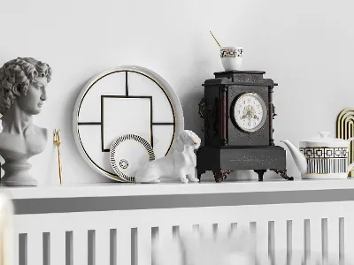 Auf einem Regal sind eine Büste, dekorative MetroChic Teller, eine Dackelfigur, eine kunstvolle Uhr und eine MetroChic Teekanne mit passender Tasse zu sehen.