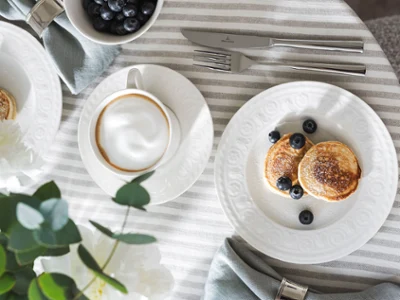 Tischgedeck mit Cellini Kollektion von Villeroy & Boch Tischgedeck mit Cellini Kollektion von Villeroy & Boch, bestehend aus einem Kaffeetasse, Pfannkuchen mit Heidelbeeren und Besteck.