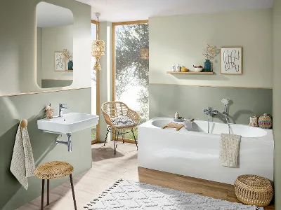 Une salle de bains avec des murs verts, des meubles en bois et une baignoire blanche ainsi qu’un lavabo blancs O.novo.