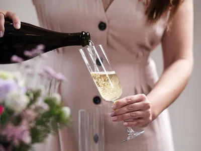 A woman pours champagne into a NewMoon champagne glass from Villeroy & Boch.