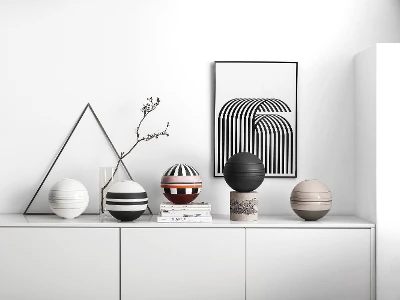 A white shelf with several La Boule dinnerware sets on top.