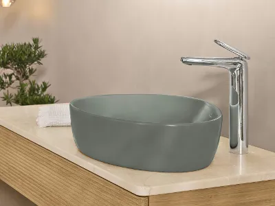 Un lavabo vert dans une salle de bains avec une robinetterie de lavabo argentée de la collection Antao de Villeroy & Boch.