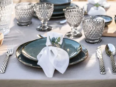Lave plate outdoors with Boston glasses on a wooden table, accentuated with a white napkin and a sprig of greenery.