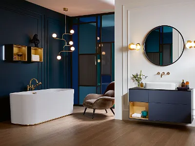 Un bagno con pareti blu, armoniosi mobili da bagno Finion e una vasca da bagno Finion bianca di Villeroy & Boch.