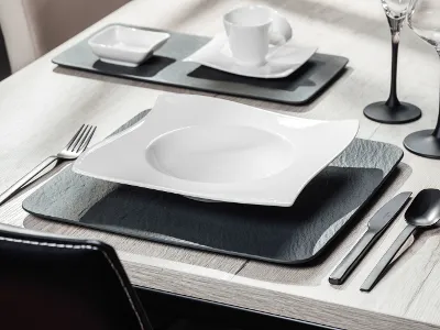 Modern table setting with Manufacture and NewMoon dinnerware and black Manufacture flatware on a neutral table cloth.