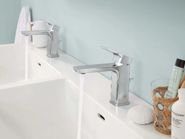 Un lavabo doppio Subway 3.0 con rubinetteria color argento in un bagno con pareti blu.