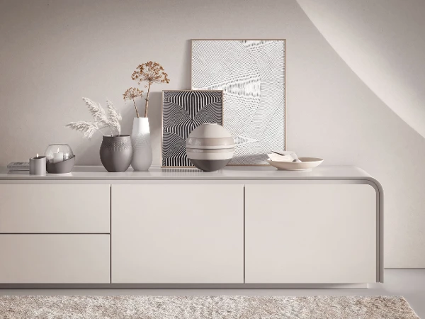 Ein weißes Sideboard mit dekorativen Manufacture Vasen, NewMoon Dekoration und La Boule von Villeroy & Boch darauf.