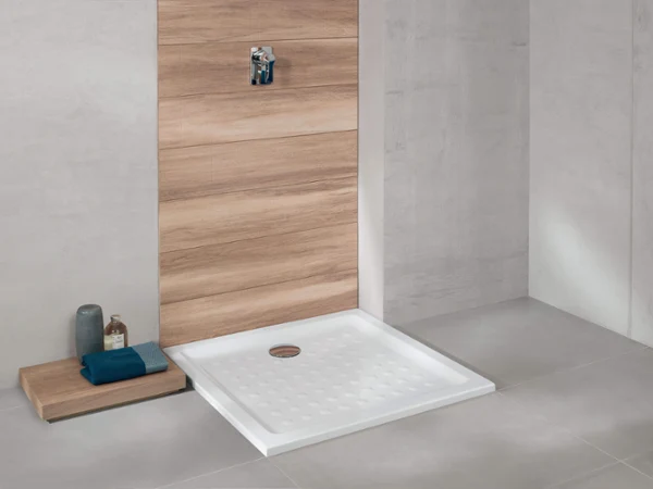 Modern shower area with a white, rectangular shower tray, wood panelling and a small bench for towels and toiletries.