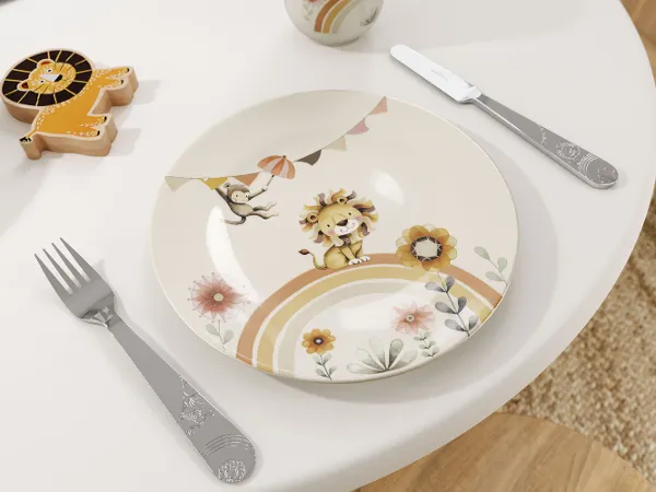 Der Kinderteller Boho Kids | Roar like a Lion von Villeroy & Boch zeigt ein Löwendesign auf einem Tisch mit Gabel und Messer, ergänzt durch eine Spielfigur in Löwenform im Hintergrund.