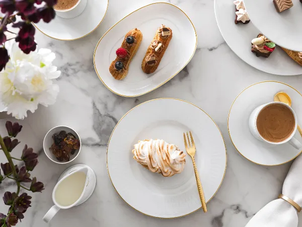 Elegante marmeren tafel met Château Septfontaines servies en gouden MetroChic bestek.