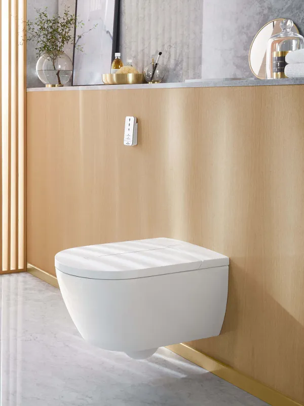 Un inodoro de ducha ViClean-I 100 blanco en un cuarto de baño gris.