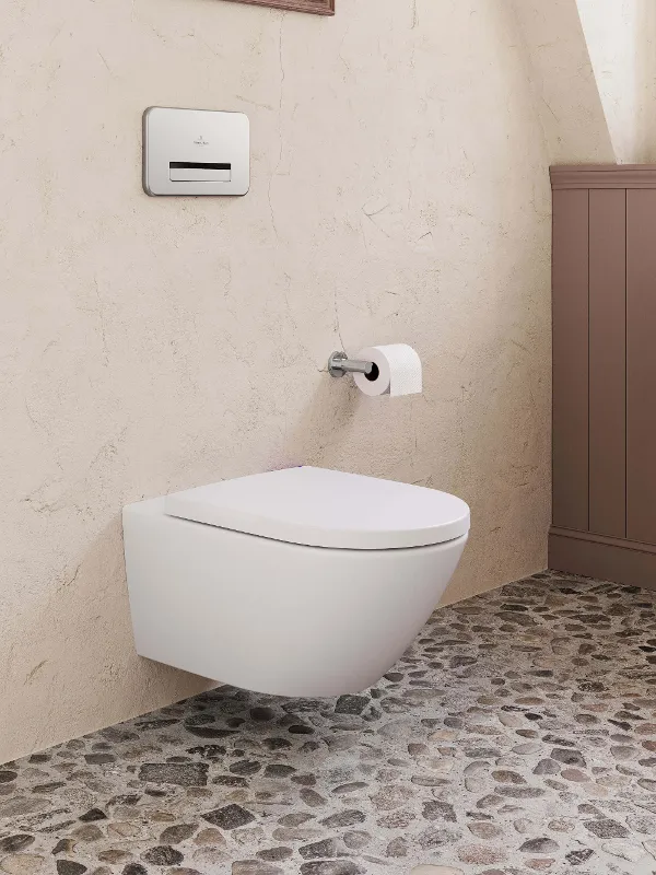 Modern wandtoilet met drukplaat in een badkamer met getextureerde muren en stenen vloer