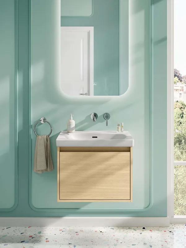 Vaskeområde med rektangulært spejl i et mintfarvet badeværelse fra Villeroy & Boch. Vaskeområdet i dette muntre, mintgrønne badeværelse består af en kombination af håndvask og underskab fra Skyla-badeværelseskollektionen samt det belyste spejl med afrundede hjørner fra More To See Lite-kollektionen.