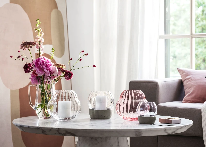 Various Rose Garden vases and hurricane lamps on a table in the living room.