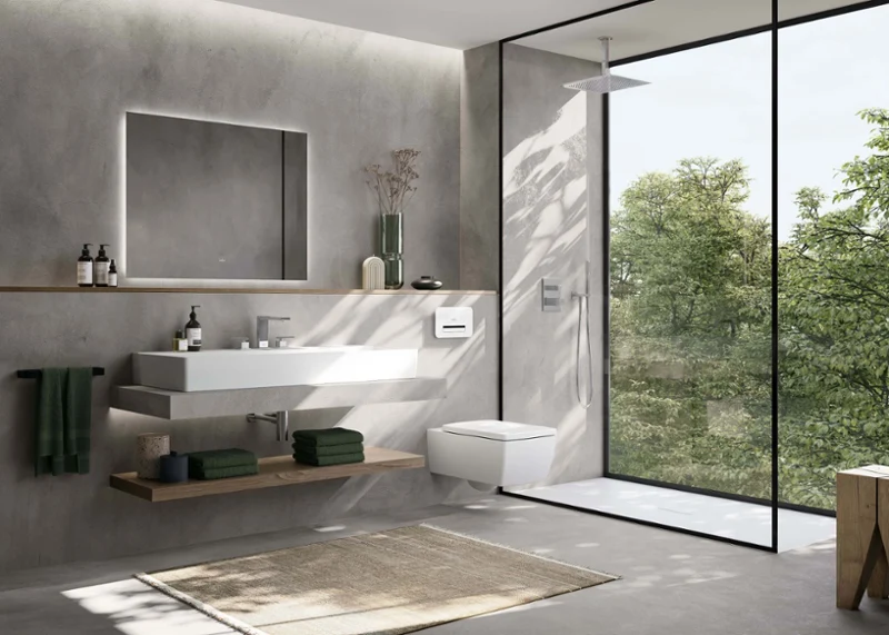 Cuarto de baño minimalista con lavabo Memento 2.0 de Villeroy & Boch e inodoro suspendido.  El diseño combina líneas limpias, sutiles paredes grises y una ducha del suelo al techo con vistas a la vegetación.