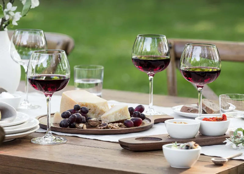 A table with Purismo red wine glasses, dip bowls and an antipasti platter from Artesano.