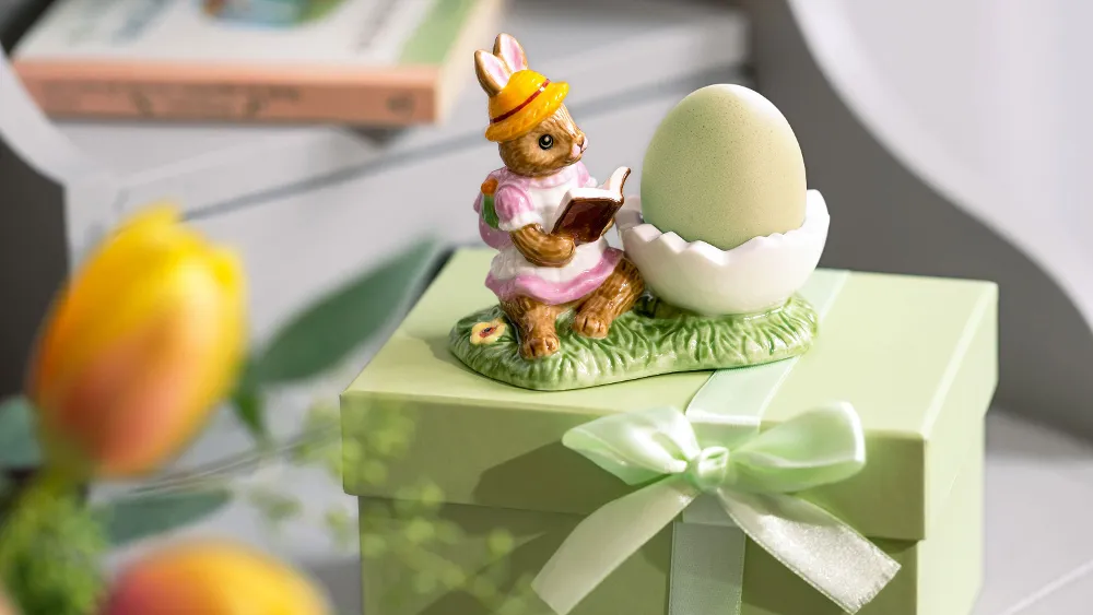 L' "Annual Easter Edition 2025" di Villeroy & Boch raffigura un coniglio che legge accanto a un uovo su una confezione regalo.