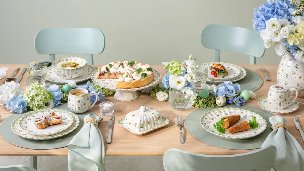 A Easter Delight dining table set for four A Easter Delight dining table set for four with Easter Delight decorations, pastel tableware, and plates of food arranged neatly.