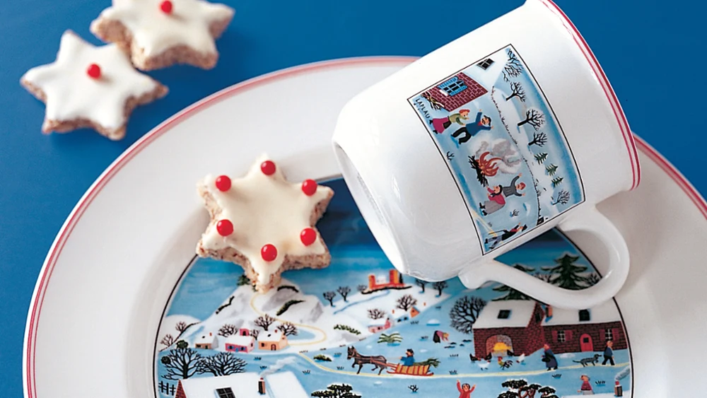 Design Naif Christmas mug on plate Design Naif Christmas mug placed on a plate with a star shaped cookie.