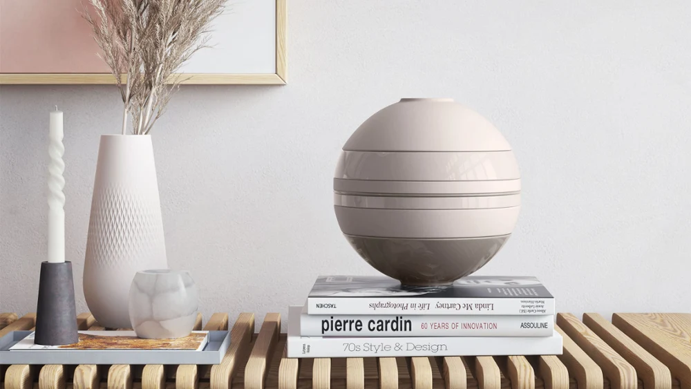 La Boule Pure Beige on a wooden table A Villeroy & Boch beige La Boule on a wooden table beside a Manufacture vase and books.